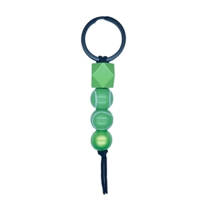 Detailed macro view of tennis-themed beaded keychain with green sports patterns