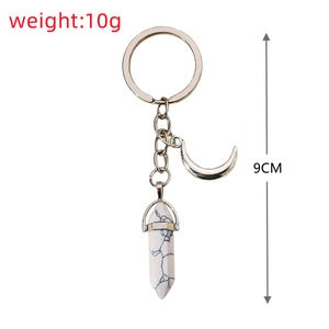 Detail of silver alloy keychain featuring white marble hexagonal prism and crescent moon charm