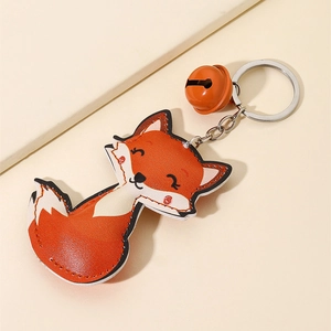Cute PU leather fox keychain with orange metal bell and silver ring on light background