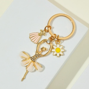 Detailed shot of golden ballerina keychain with rhinestones and white daisy charm