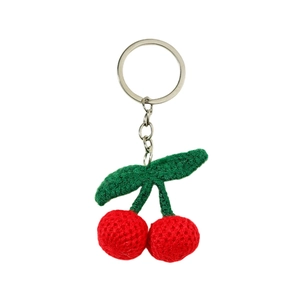 Handmade crochet red cherry keychain with green leaves and silver metal ring on white background
