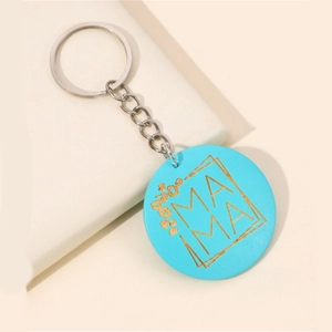 Détail du porte-clés MAMA bleu rond avec lettrage doré et motifs léopard
