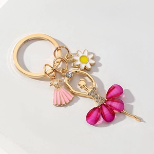 Golden ballet girl keychain with rhinestone crystal dress and daisy pendant on white background