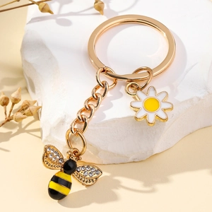 Porte-clés abeille et marguerite en métal doré avec strass sur socle en marbre