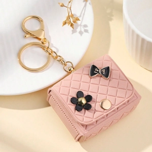 Macro view of pink quilted leather mini coin purse with bow ornament and gold ring
