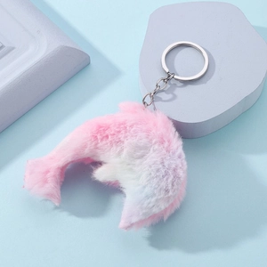Cute plush dolphin keychain with pink and purple gradient fur on light blue background