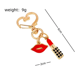 Detailed view of lipstick and red lip keychain charms with dimensions 6x2cm and 9g weight