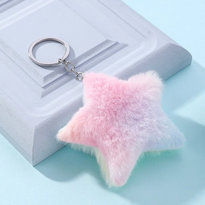 Plush gradient pink and purple star keychain displayed on a modern stone base stand