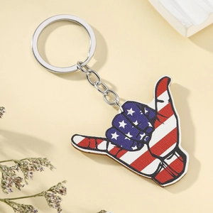 Detail of wooden shaka hand keychain with American flag print on rustic background