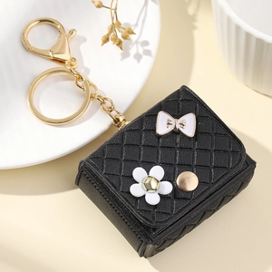 Mini black quilted pouch keychain with white bow and floral detail for headphones