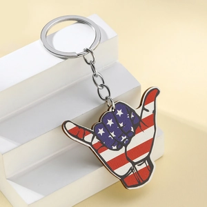 Macro detail of wood Shaka sign keychain with American flag print and silver ring