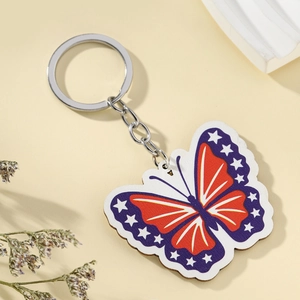 USA flag butterfly keychain with star and stripe patterns on a soft yellow background