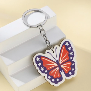 Detail view of the colorful American flag butterfly keychain on a white display stand