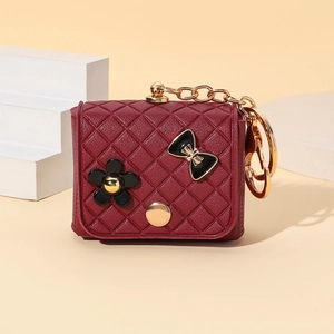 Detail of burgundy quilted mini bag keychain with black flower and golden chain