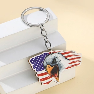 Close-up of eagle head and US flag pattern keychain on white geometric stand
