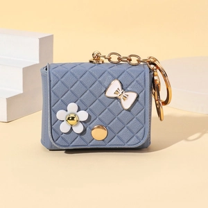 Detailed close-up of blue quilted mini purse keychain with floral and bow charms