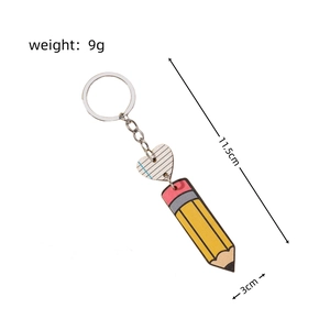 Detailed view showing pencil and wooden heart charms on a silver metal keychain
