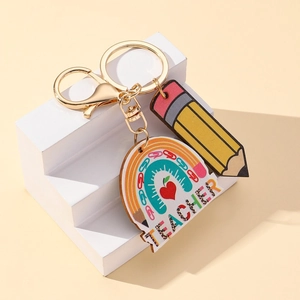 Rainbow pencil teacher keychain with gold lobster clasp on minimalist display stand