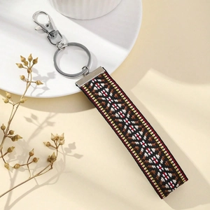 Close-up of ethnic embroidered keychain with colorful geometric patterns and lobster clasp