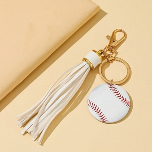 Baseball keychain featuring a white tassel and golden lobster clasp on a beige background