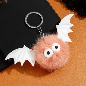 Détail du porte-clés chauve-souris en fausse fourrure rose avec yeux de dessin animé et ailes
