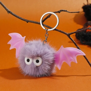 Détail du porte-clés chauve-souris en fausse fourrure violette avec ailes roses sur branche