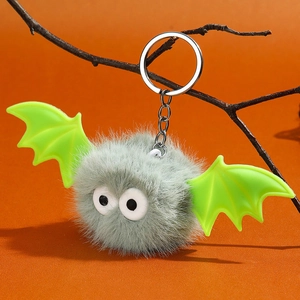 Détail d'un porte-clés chauve-souris en peluche grise avec ailes vertes
