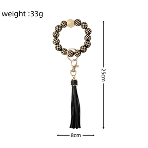 Detailed view of checkered bead keychain with black tassel and golden hardware measurements