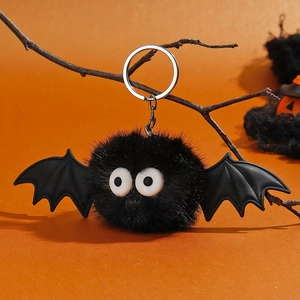 Détail d'un porte-clés chauve-souris d'Halloween sur une branche et fond orange