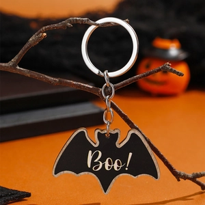 Halloween vleermuis sleutelhanger met Boo-tekst hangend bij pompoen decoraties