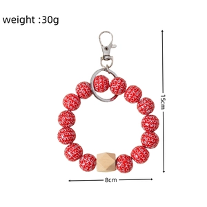 Detail of red XOXO beaded keychain bracelet with wood bead and silver lobster clasp