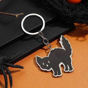 Detail van Halloween zwarte kat sleutelhanger met zilveren ring op een griezelige achtergrond