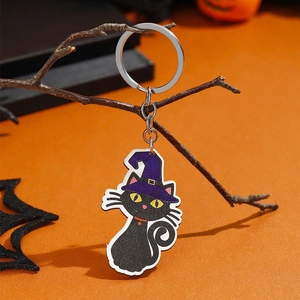 Detailopname van Halloween zwarte kat sleutelhanger met heksenhoed op oranje achtergrond
