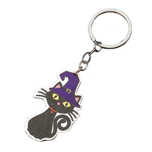 Halloween sleutelhanger detail: zwarte kat met paarse heksenhoed op een witte achtergrond
