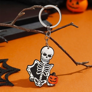 Halloween skelet sleutelhanger met mini pompoen hangend aan decoratieve takken