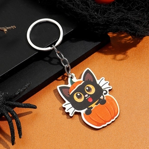 Detail van een Halloween-sleutelhanger met zwarte kat en pompoen op gepolijst acryl