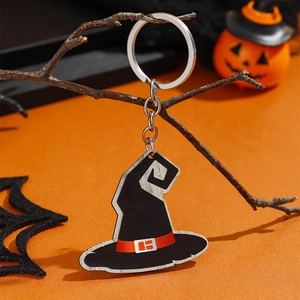 Detail van een zwarte heksenhoed sleutelhanger aan een tak met Halloween-achtergrond