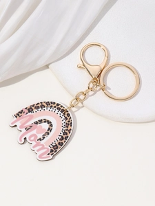 Detail of colorful rainbow MOM keychain with gold metal clasp on white satin background
