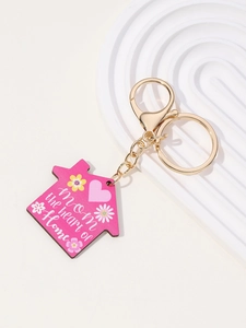 Detail of pink house-shaped MOM keychain with floral pattern and gold lobster clasp