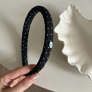 Retro black headband with white polka dots and blue handmade tag on white ceramic tray
