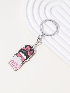 Close-up of No. 1 Mom acrylic keychain with female silhouette and pink bow on white ripple board