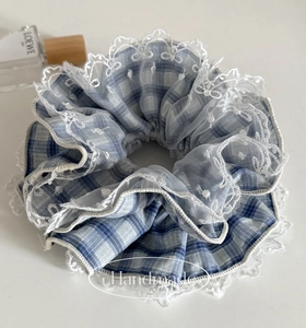 Detail of blue plaid scrunchie with lace trim and handmade embroidery craftsmanship