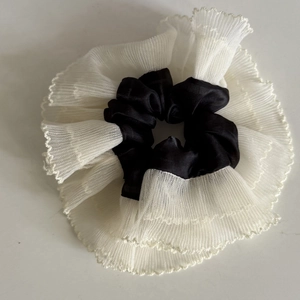 Detail of contrast tulle and black satin hair scrunchie with pleated wavy lace edges