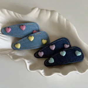 Set of four sweet denim heart hair clips in light and dark blue with colorful resin hearts