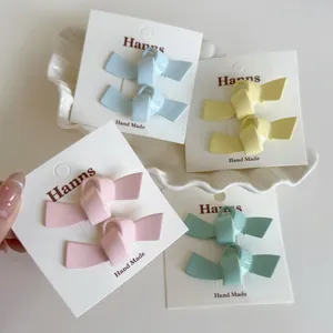 Set mit farbenfrohen matten Schleifen-Haarspangen in Pastellrosa Gelb Blau und Grün