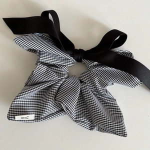 Elegant black and white checkered scrunchie with large bow for a French chic hair style