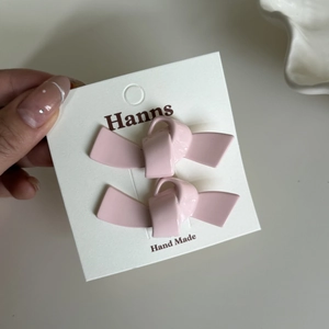 Detailansicht der rosa Schleifen-Haarspangen auf Markenkarte mit Glanzeffekt