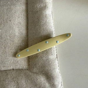 Barrette à cheveux crème chic à pois bleus sur un fond en tissu texturé neutre
