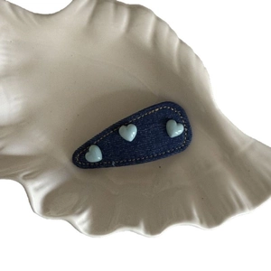 Blue denim BB hair clip with three light blue hearts and yellow stitching on shell plate