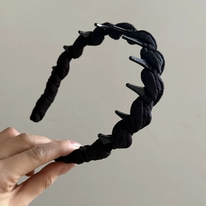 Détail montrant les dents en plastique antidérapantes et la texture tressée noire du serre-tête